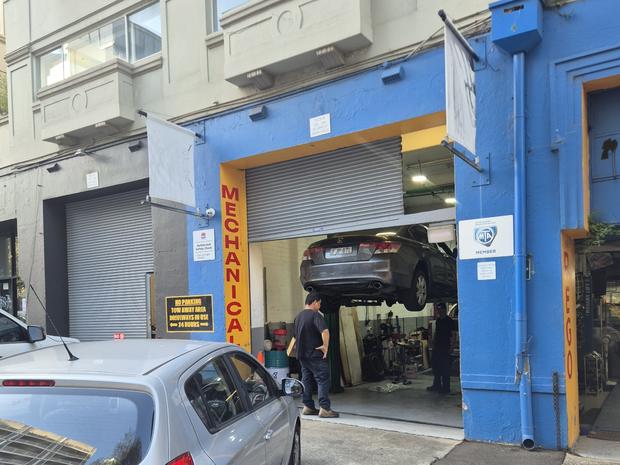 The mechanical workshop entrance at Shop 5, 342-344 Bourke Street, Surry Hills, with a car on the hoist